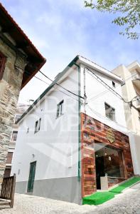 a white building with a bench in front of it at Casa da Padaria Antiga 1 in Pinhão