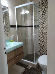 ein Bad mit einer Dusche, einem Waschbecken und einem WC in der Unterkunft FLATS Atlantico Praia in Rio de Janeiro
