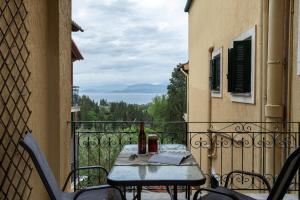 un tavolo e sedie su un balcone con vista di Roxandra Suite Corfu a Evropoúloi