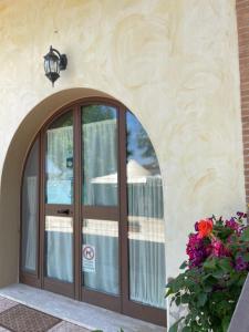 een ingang naar een gebouw met een deur en bloemen bij La Lestra in San Felice Circeo