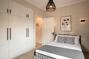 1 dormitorio con 1 cama y armarios blancos en Roxandra Suite Corfu en Evropoúloi
