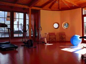 a gym with exercise equipment in a room with windows at Sportpension Aichholzer in Oberaichwald