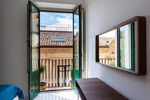 een kamer met uitzicht op een balkon met een raam bij Kapitano Apartments in Taormina