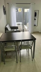 - Sala de estar con mesa y 2 sillas en Depto Magallanes, en Ushuaia
