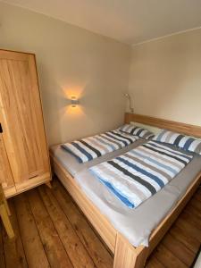 uma cama com um edredão listrado num quarto em Strandläufer em Cuxhaven