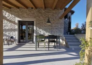 un patio con tavolo e sedie su un edificio di Two villas in lush countryside near Motovun a Brkač
