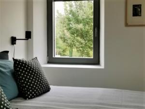 una camera da letto con finestra e letto con cuscino di Two villas in lush countryside near Motovun a Brkač Altre 37 foto