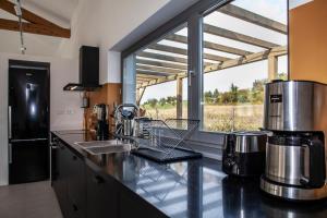 una cucina con piano di lavoro e ampia finestra di Two villas in lush countryside near Motovun a Brkač