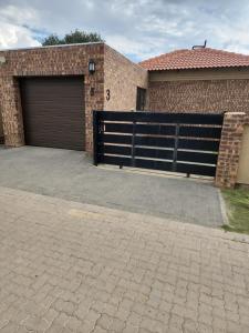a garage with a garage door and a brick building at Lloyds - 3 in Ermelo