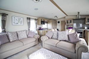 a living room with two couches and a kitchen at Beautiful Lodge At Manor Park In Hunstanton Ref 23018k in Hunstanton