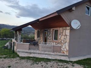 ein kleines Haus mit einer Veranda und einer Terrasse in der Unterkunft Stefan in Nikšić