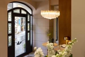 um quarto com um lustre e uma mesa com flores em Taodomus Small Boutique Hotel em Taormina