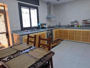 a kitchen with a table and a stove and a table and chairs at Ghougine Serenity Residence in Tangier