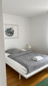 1 cama blanca en un dormitorio con una pared blanca en East View, en Freudenstadt