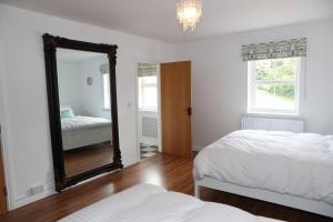 a bedroom with two beds and a mirror at 4 Castle Court in Killyhevlin