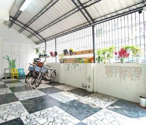 上海民宿 في Chaozhou: بيت زجاجي به دراجة متوقف في غرفة بها نباتات