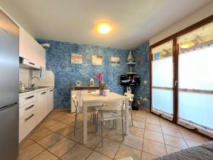 a kitchen with a white table and a kitchen with blue walls at Porto Antico Village in Aprilia Marittima