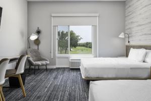 a hotel room with two beds and a chair and a window at TownePlace Suites by Marriott San Antonio Universal City, Live Oak in Selma