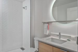 a bathroom with a sink and a toilet and a mirror at TownePlace Suites by Marriott San Antonio Universal City, Live Oak in Selma +16 photos