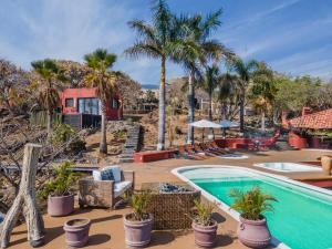 ein Resort mit einem Pool und Palmen in der Unterkunft Casanevo Suite - outdoor Jacuzzi - Mountain views in Tepoztlán