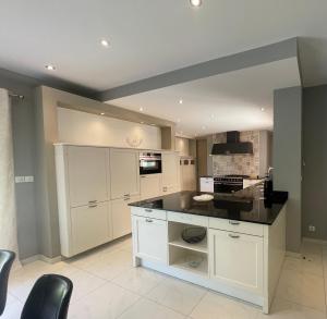 kuchnia z białymi szafkami i czarnym blatem w obiekcie VILLA PALMIER avec PISCINE CHAUFFÉE PRIVÉE proche D'UZES ET ANDUZE w mieście Cannes-et-Clairan