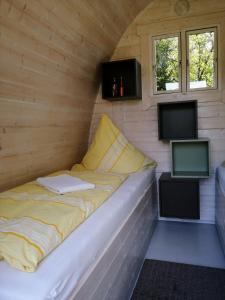ein Bett in einem winzigen Haus mit zwei TVs in der Unterkunft Hotel Zum Birkenhof in Burow