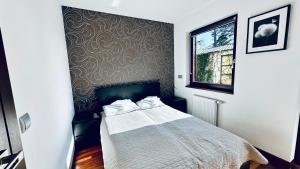 a bedroom with a bed and a wall at Aqua Villa 4 in Jurata
