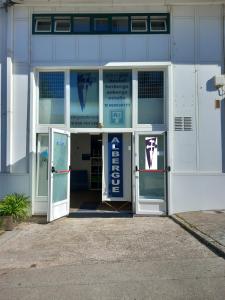 un edificio con una puerta abierta con un cartel. en Albergue Monterrey, en Santiago de Compostela