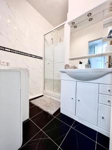巴黎的住宿－Champs Elysées 2，白色的浴室设有水槽和淋浴。