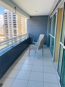 a balcony with two chairs and blue tiles at Beach Class Fortaleza by AM in Fortaleza