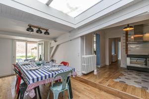 een eetkamer met een tafel met stoelen en een plafond bij Maison avec jardin et parking gratuit in Étretat