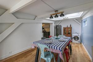 een eetkamer met een tafel en stoelen bij Maison avec jardin et parking gratuit in Étretat