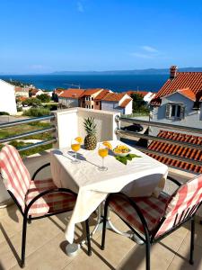 a table with two glasses of wine on a balcony at Vespera Apartments in Bol