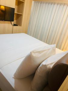 1 dormitorio con cama blanca y almohada en Beach Class Fortaleza by AM, en Fortaleza