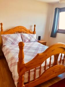 ein Holzbett mit einem Holzrahmen in einem Schlafzimmer in der Unterkunft Invercaul House in Inverness
