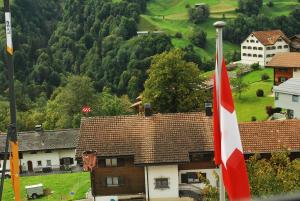 a flag is flying in front of a village at Rooms with Private bathrooms in Saas