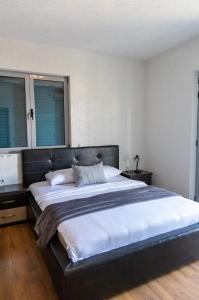 1 cama grande en un dormitorio con 2 ventanas en Sunshine Apartments en Ulcinj