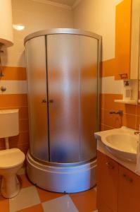 y baño con ducha, aseo y lavamanos. en Sunshine Apartments en Ulcinj
