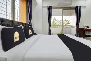 Postel nebo postele na pokoji v ubytování Townhouse OAK Red Velvet Suites & Inn Koregoan Park