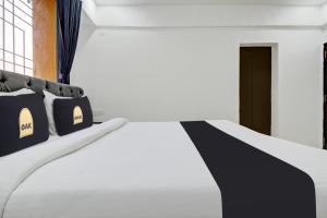 uma cama com almofadas pretas e brancas num quarto em Townhouse OAK Red Velvet Suites & Inn Koregoan Park em Pune