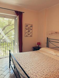 um quarto com uma cama e uma grande janela em Residenze l'Alberata em Collazzone
