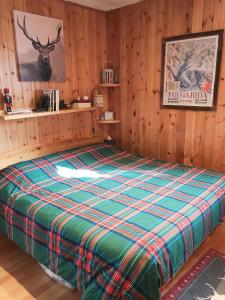 a large bed in a room with wooden walls at Casetta dei Cuori - Alpine Style Cozy Apartment in Folgarida
