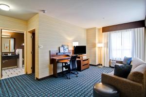 a hotel room with a desk with a computer and a couch at Fairfield Inn & Suites by Marriott Kamloops in Kamloops