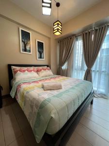 a bedroom with a large bed and a large window at NAIA Condo Palm Tree 2 in Manila