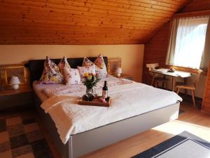 ein Schlafzimmer mit einem Bett mit Blumen und einer Flasche Wein in der Unterkunft Bergbauernhof Rebernig in Lendorf