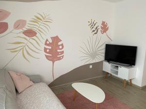 uma sala de estar com um sofá e uma televisão de ecrã plano em MINT&ROSE em Peroj