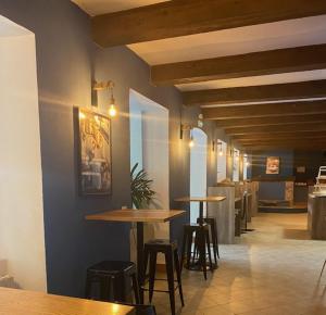 a restaurant with tables and stools in a room at HOTEL ST SEBASTIEN in Roquebillière