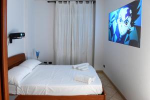 アルゲーロにあるCasa Vacanza Il Dolce Mareの小さなベッドルーム1室(壁にビデオスクリーン付きのベッド1台付)