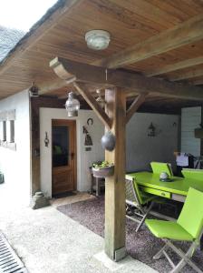 a patio with a green table and chairs at Maison dans un environnement boisé très calme in Morlaix