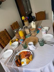 a table with a plate of breakfast food on it at Room in family home near Penny Lane Liverpool in Liverpool
